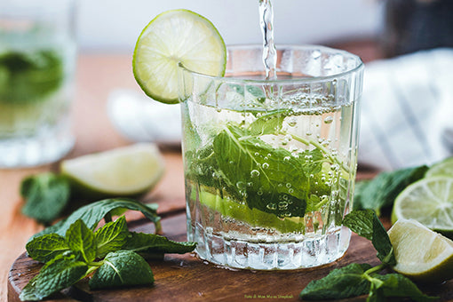 bicchiere con acqua, foglie di menta e limone